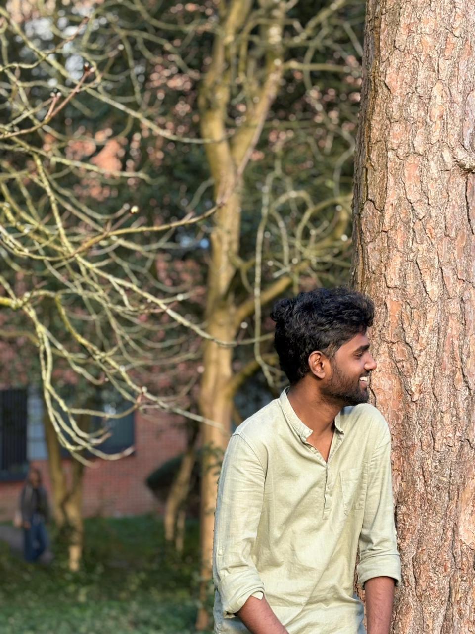 Krishnakumar standing outdoors, surrounded by trees